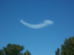 An odd shaped cloud on a clear day.